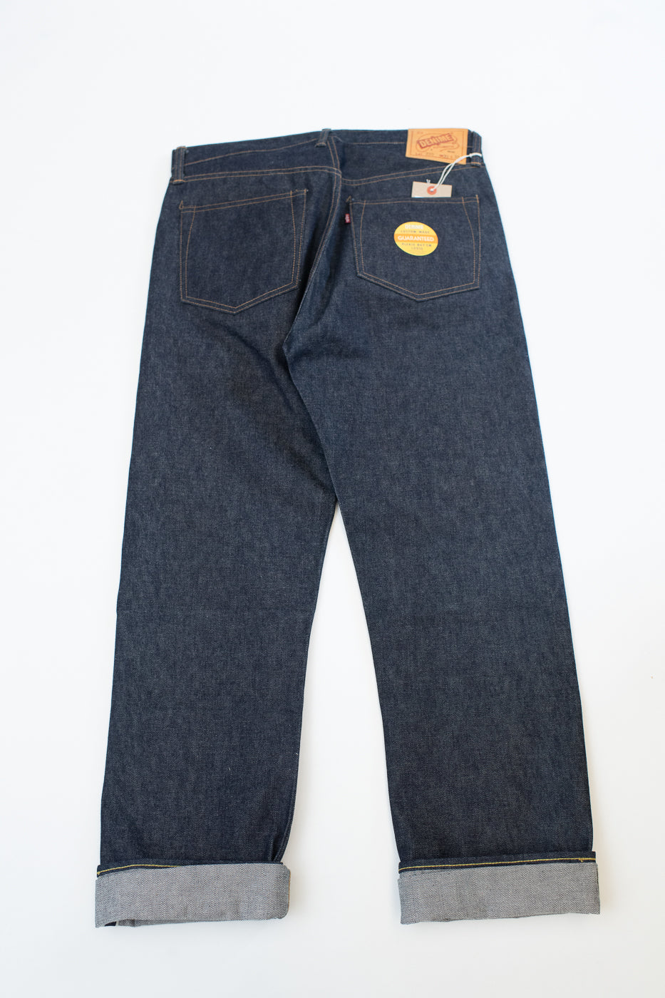 Pair of blue jeans with a brand label on a white background