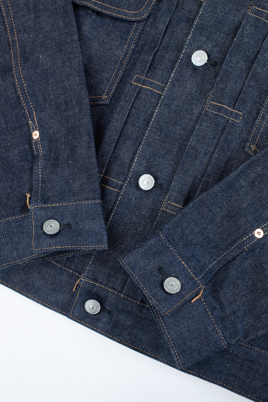 Close-up of a blue denim jacket with buttons on a white background