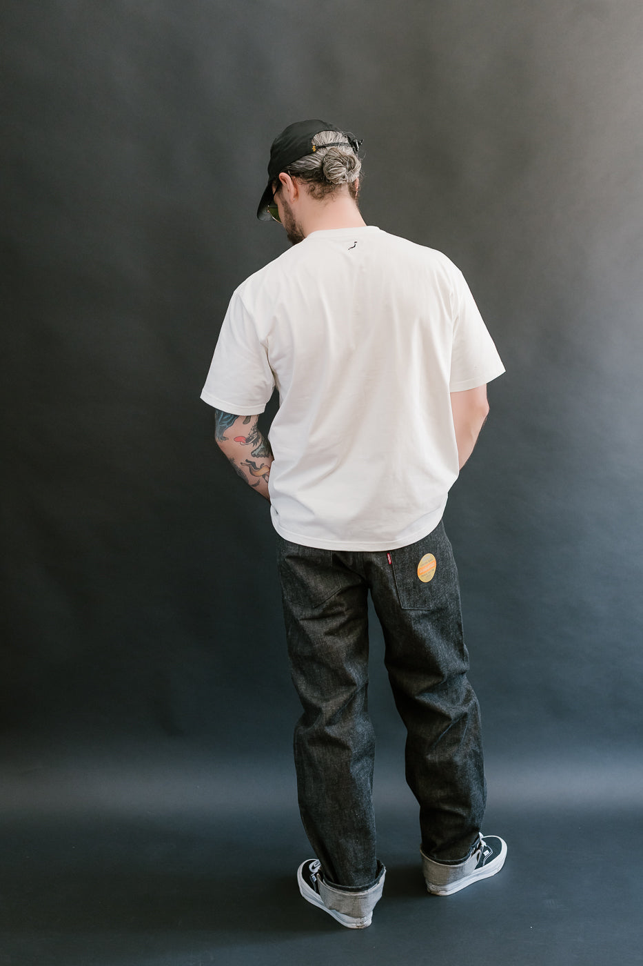 man wearing black mother cotton denim jeans full body, back