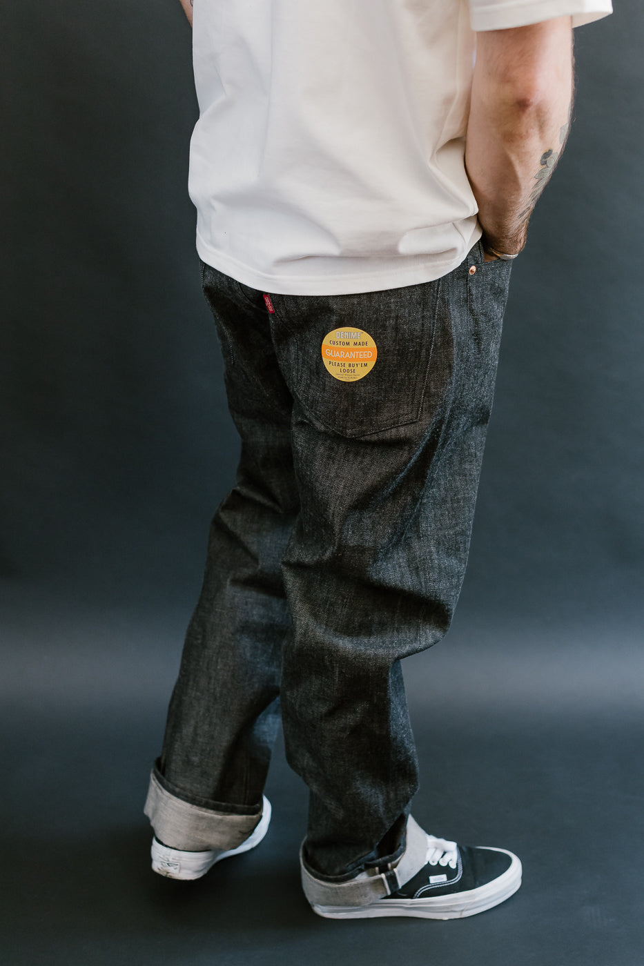 man wearing denime black mother cotton denim jeans 3/4 view, side