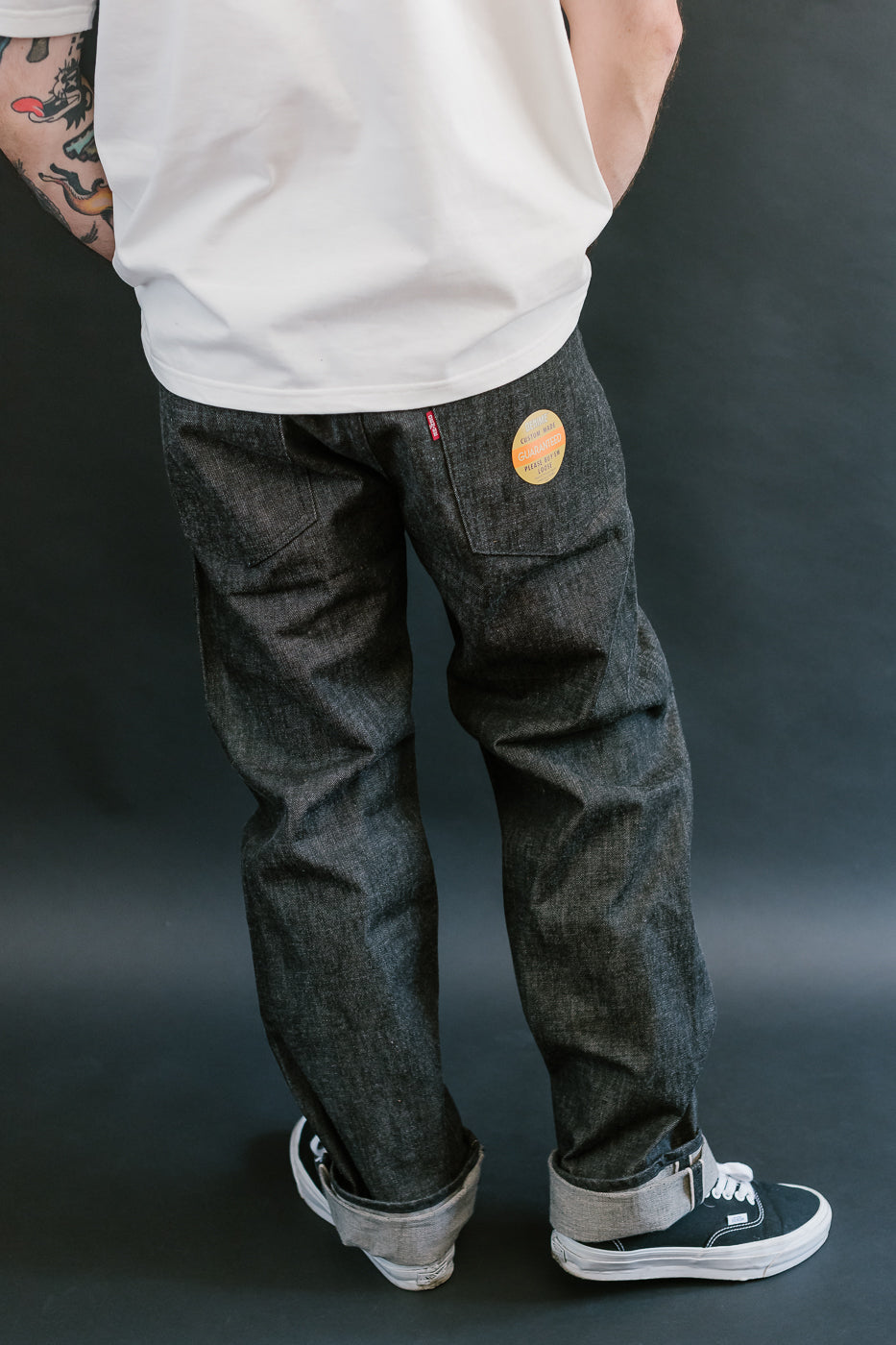 man wearing denime black mother cotton denim jeans 3/4 view, back
