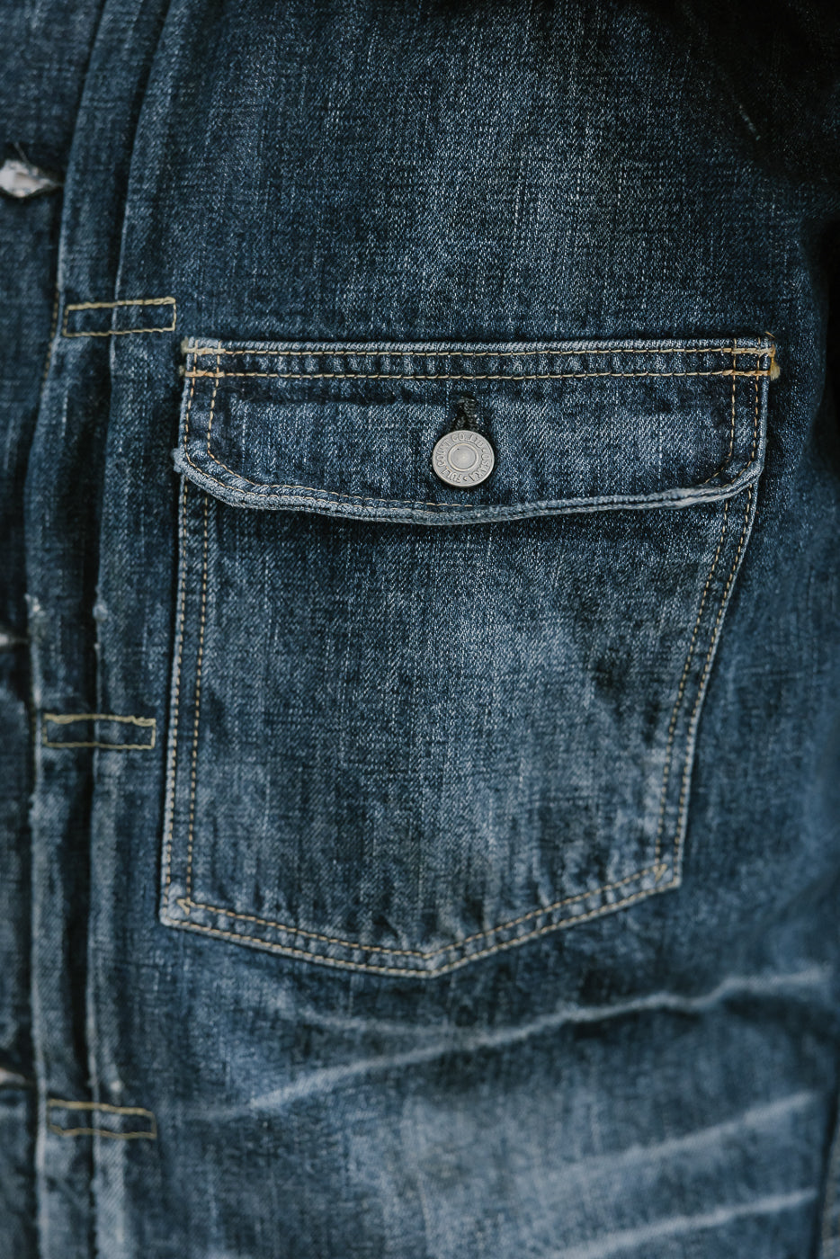Bearded man wearing Heavily washed indigo denim jacket. Close up of Type I pocket.