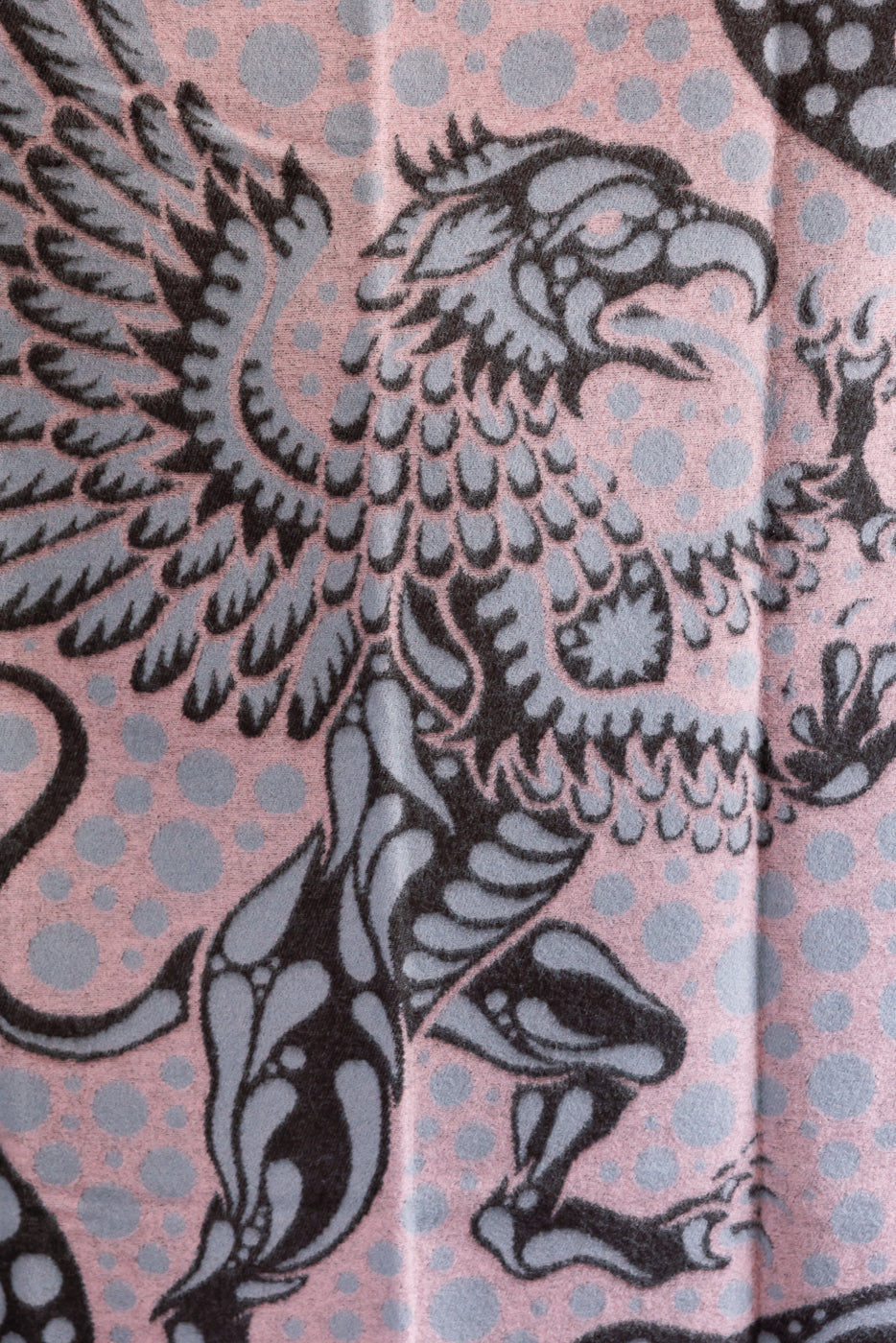 close up of pink blanket with grypon, wings, and bubble pattern, front