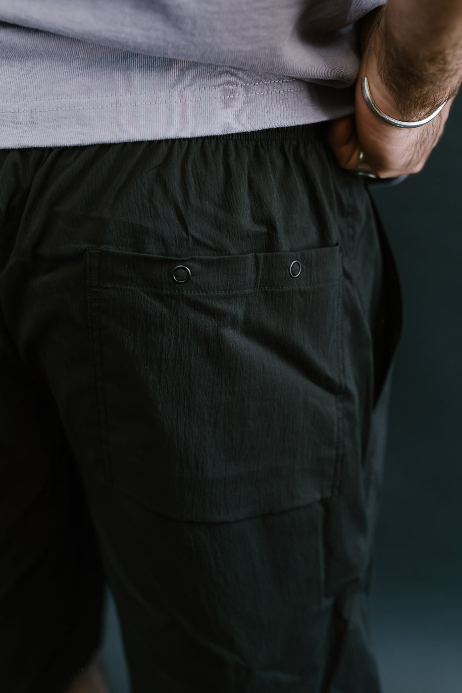 Pocket shot of person wearing black crepe pants with snaps.
