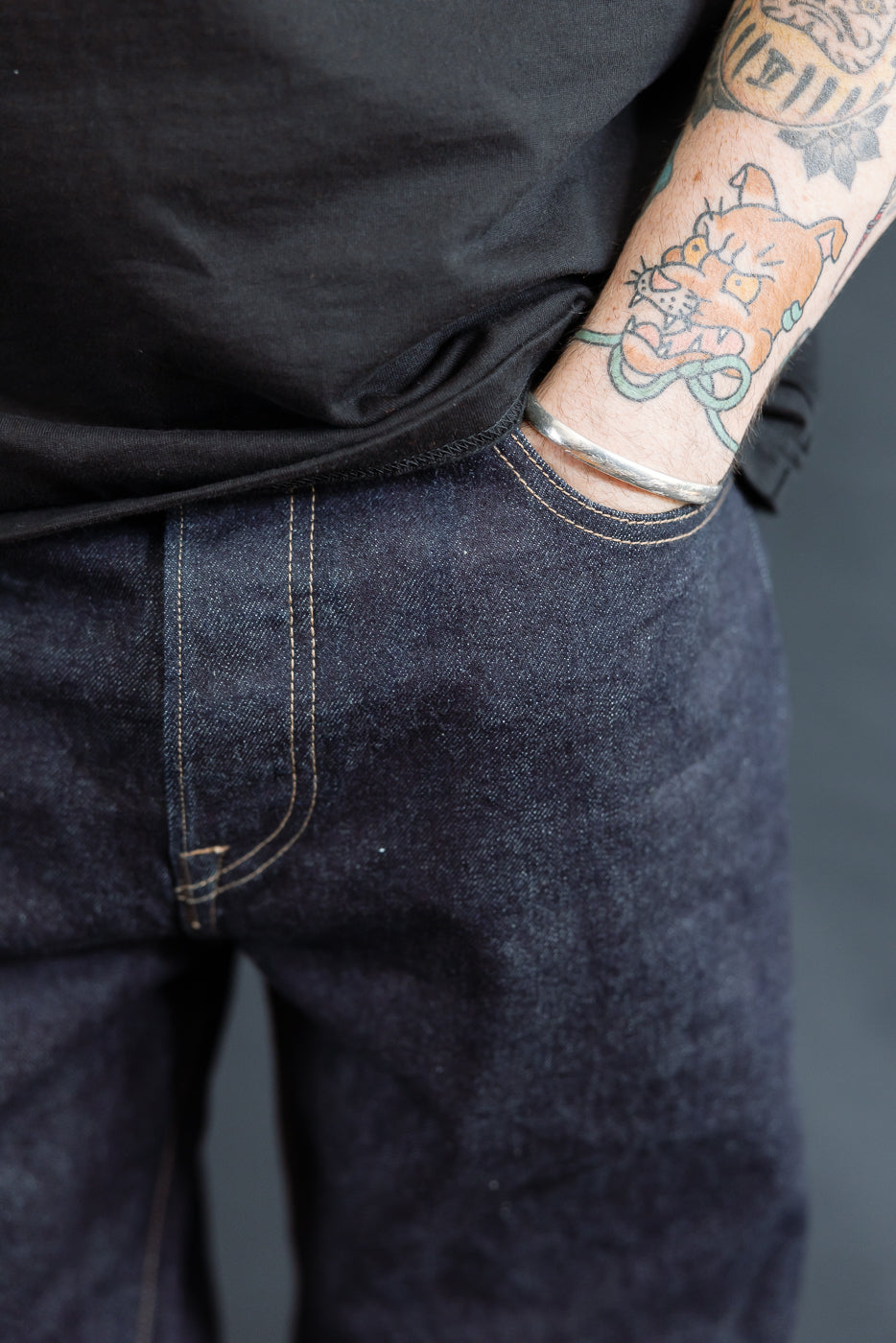 close up of RGT 15oz rinsed selvedge, hand in front left pocket, keyhole detail
