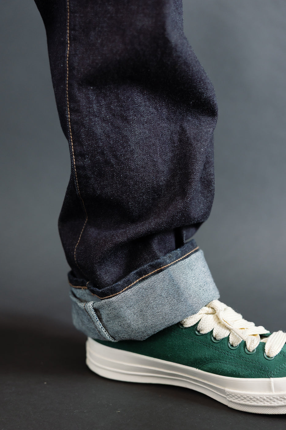 close up of RGT 15oz rinsed selvedge, interior cuff with green shoes