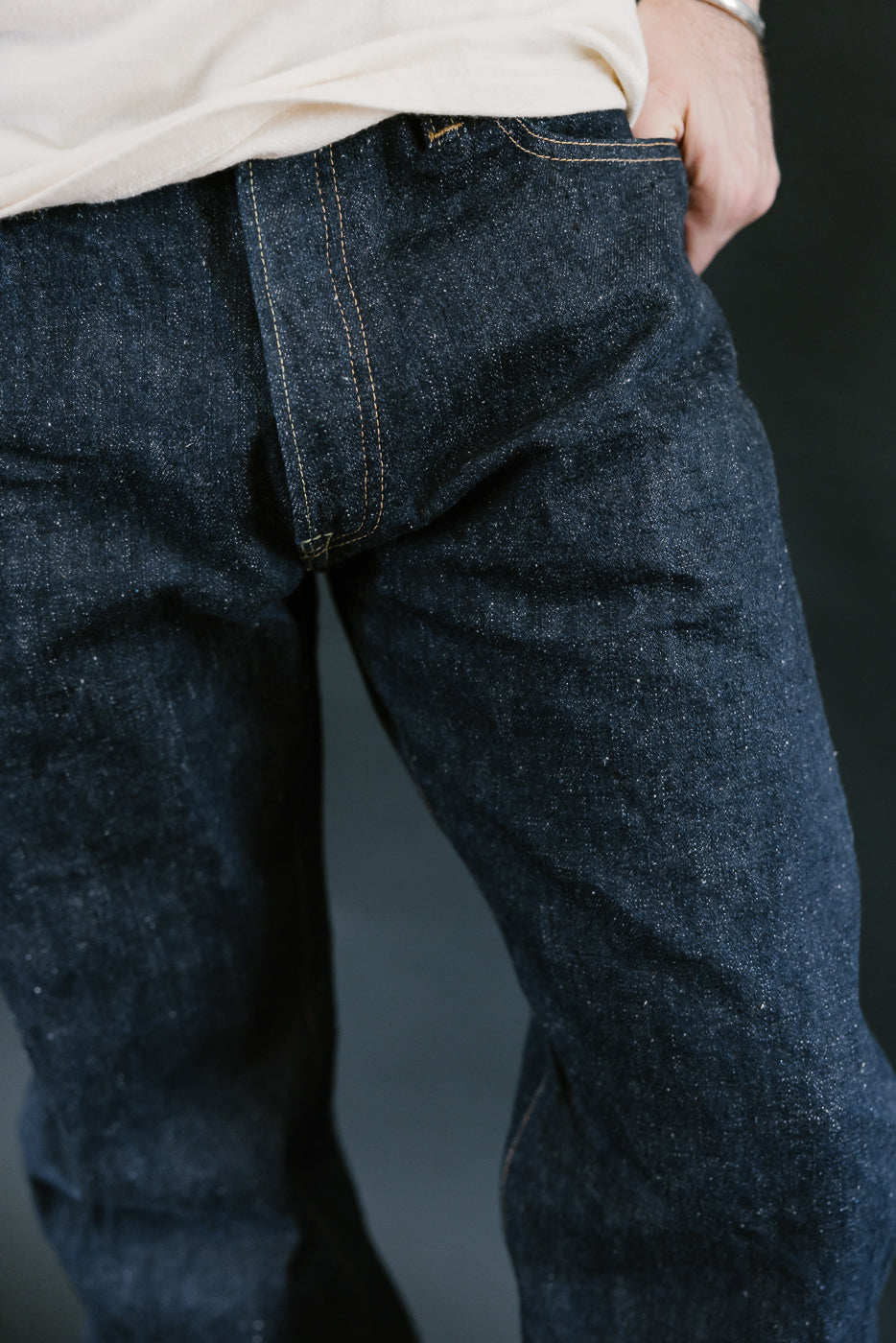 Close-up of Samurai S500AX-SAKURA jeans, showcasing the 18oz AI-PLUS denim with intricate sakura-dyed weft and slubby texture, highlighting premium Japanese craftsmanship.