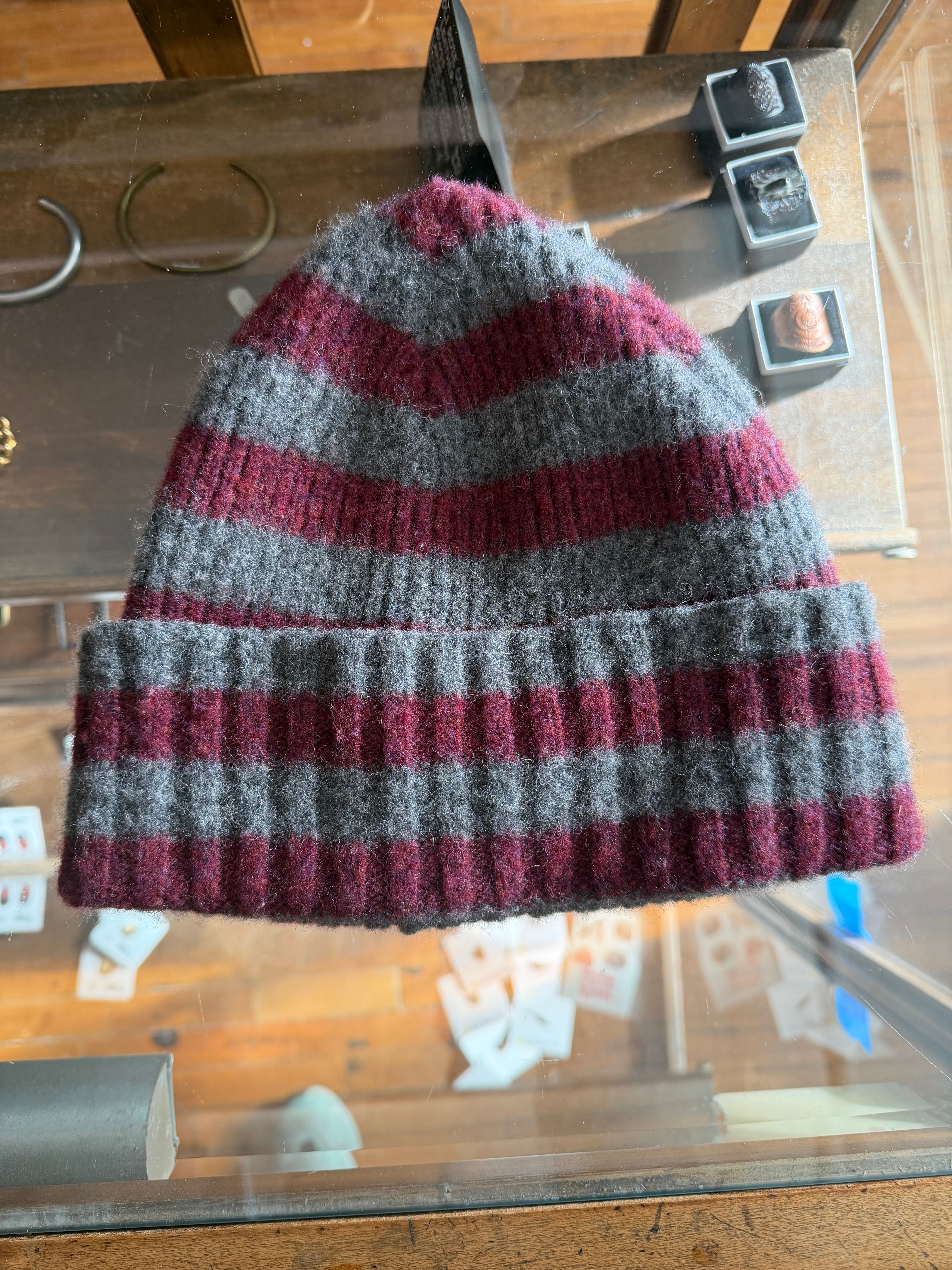 Close-up of striped wool beanie in burgundy and gray, front view, ribbed knit texture, Dant shop.