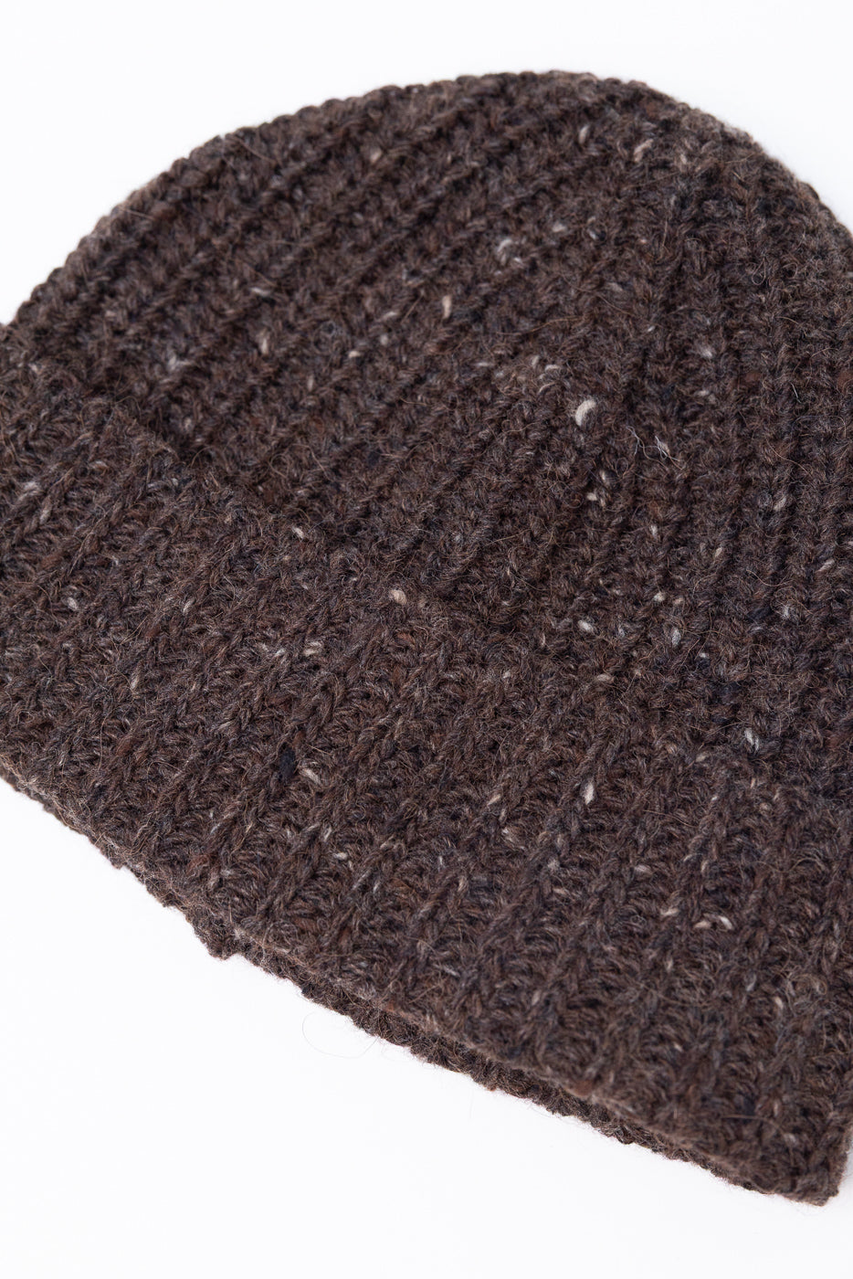 Close-up front view of a dark brown ribbed knit beanie showing detailed wool texture.