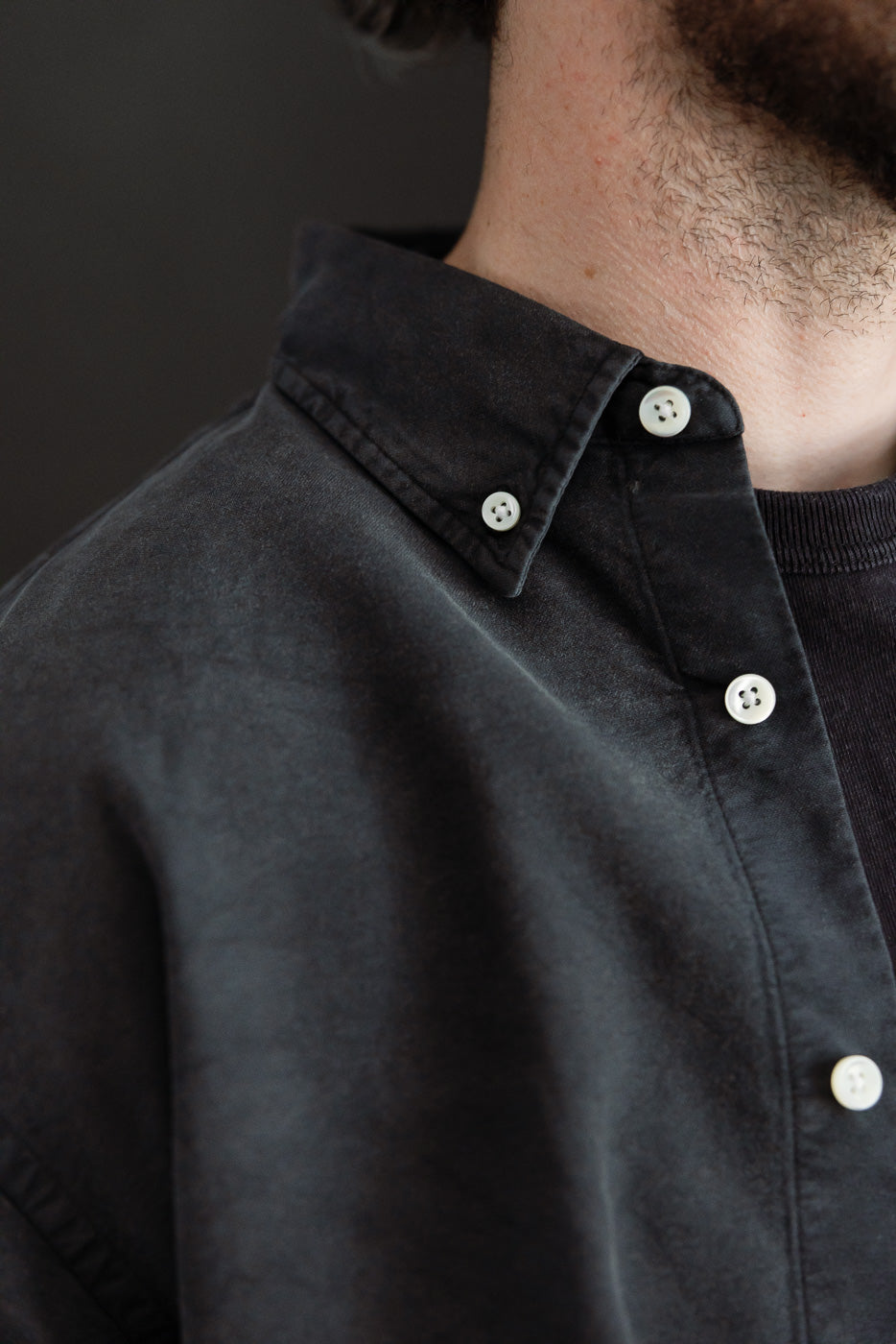 Close-up of vintage black oxford shirt front collar and buttons on male model, Dant apparel