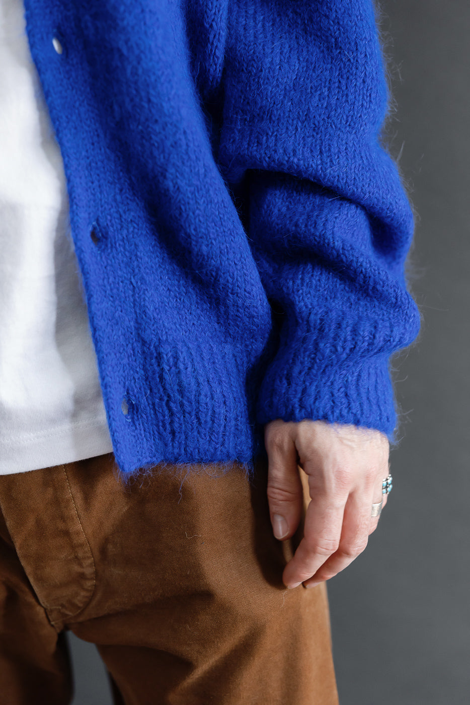 Close-up side view of a cobalt blue mohair cardigan on a male model, 5'9