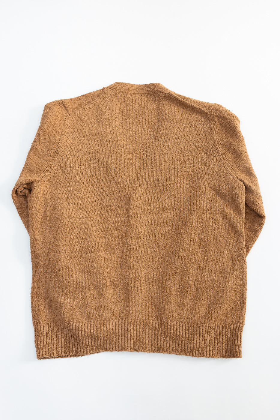 Flat lay of ochre boucle cardigan, back view, showing textured knit and ribbed hem details.