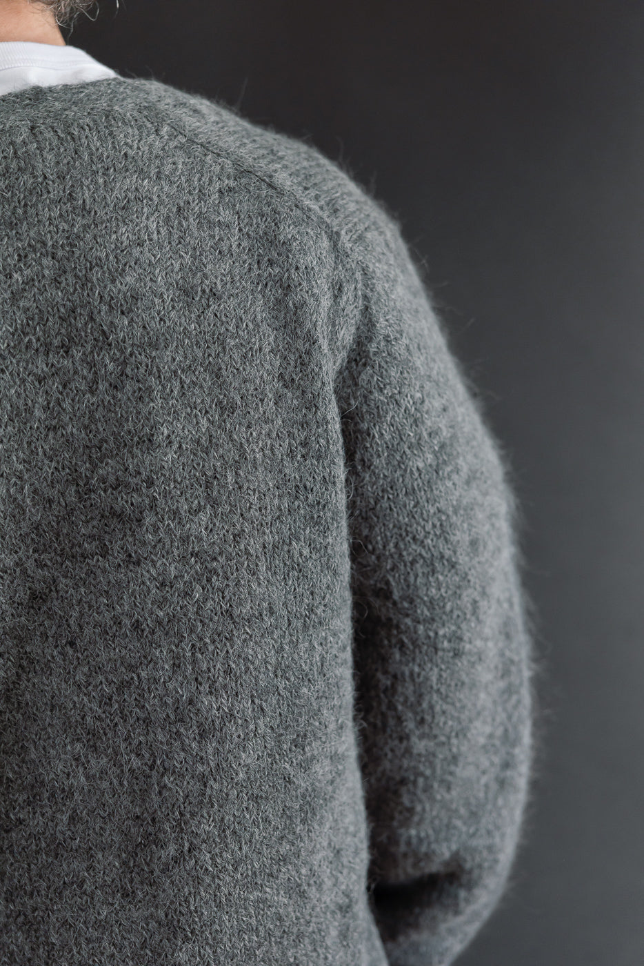 Close-up back view of a grey knit sweater on a male model, 5'9