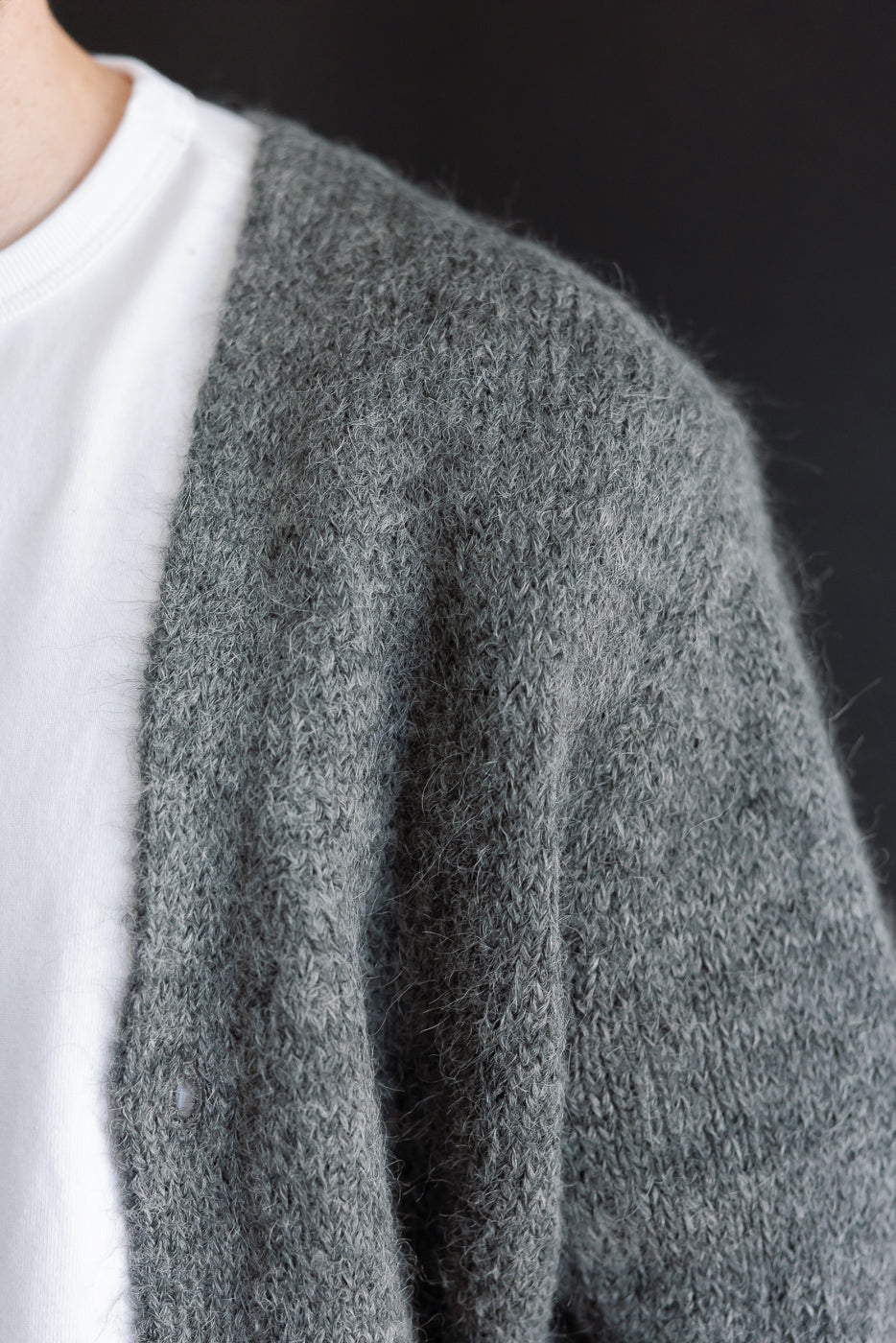 Close-up of grey knit cardigan texture on male model, 5'9