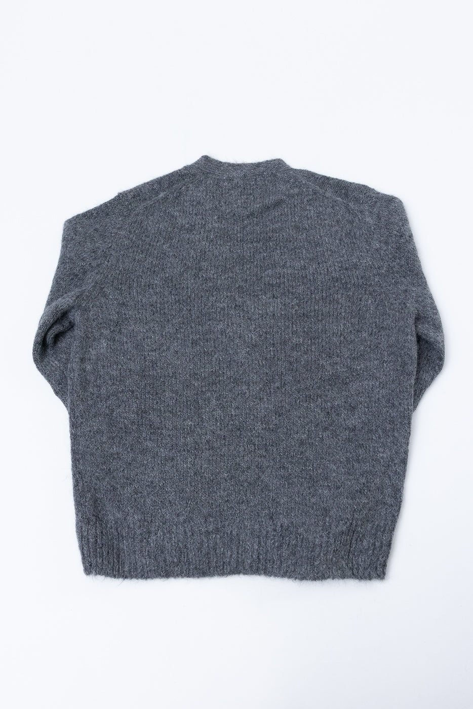 Flat lay of the back of a grey textured knit sweater.