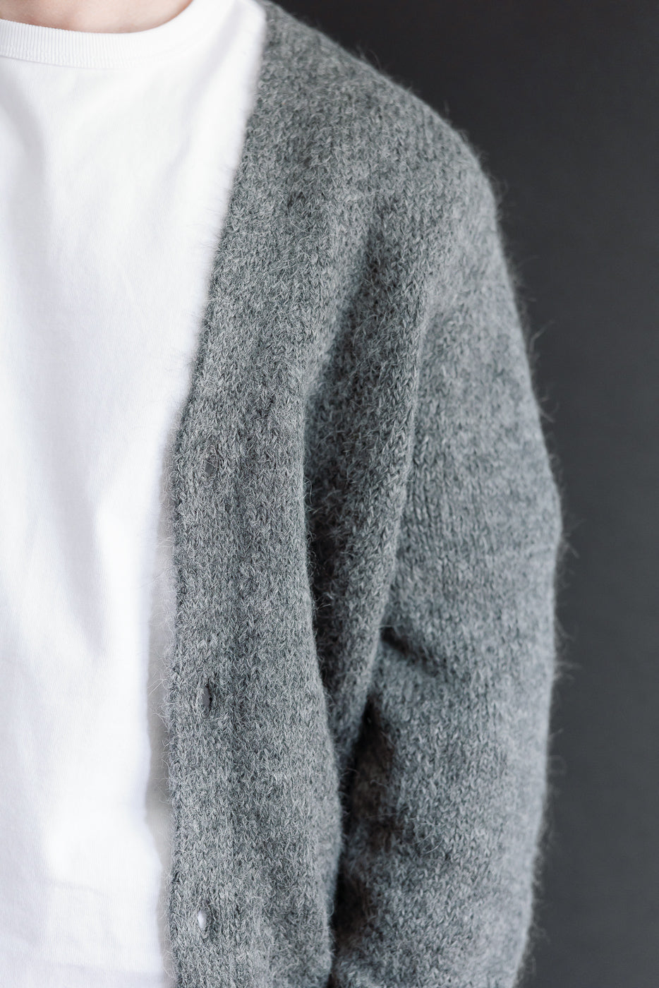 Close-up of right side of a grey knit cardigan on a male model, 5'9