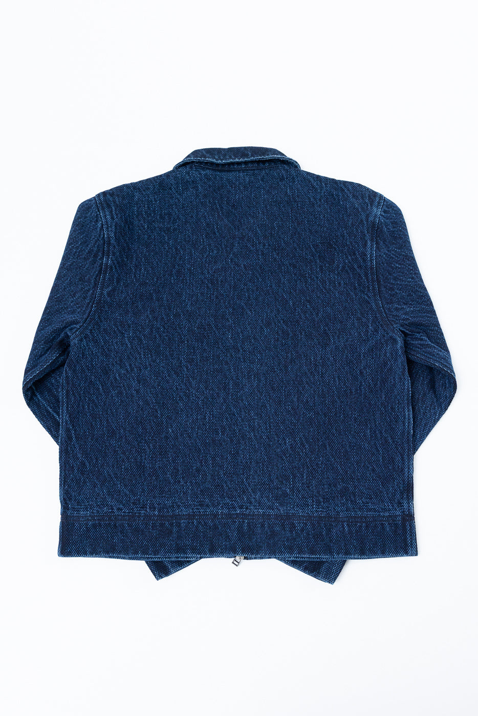 Back view flat lay of a dark blue denim jacket showing fabric texture and hem.