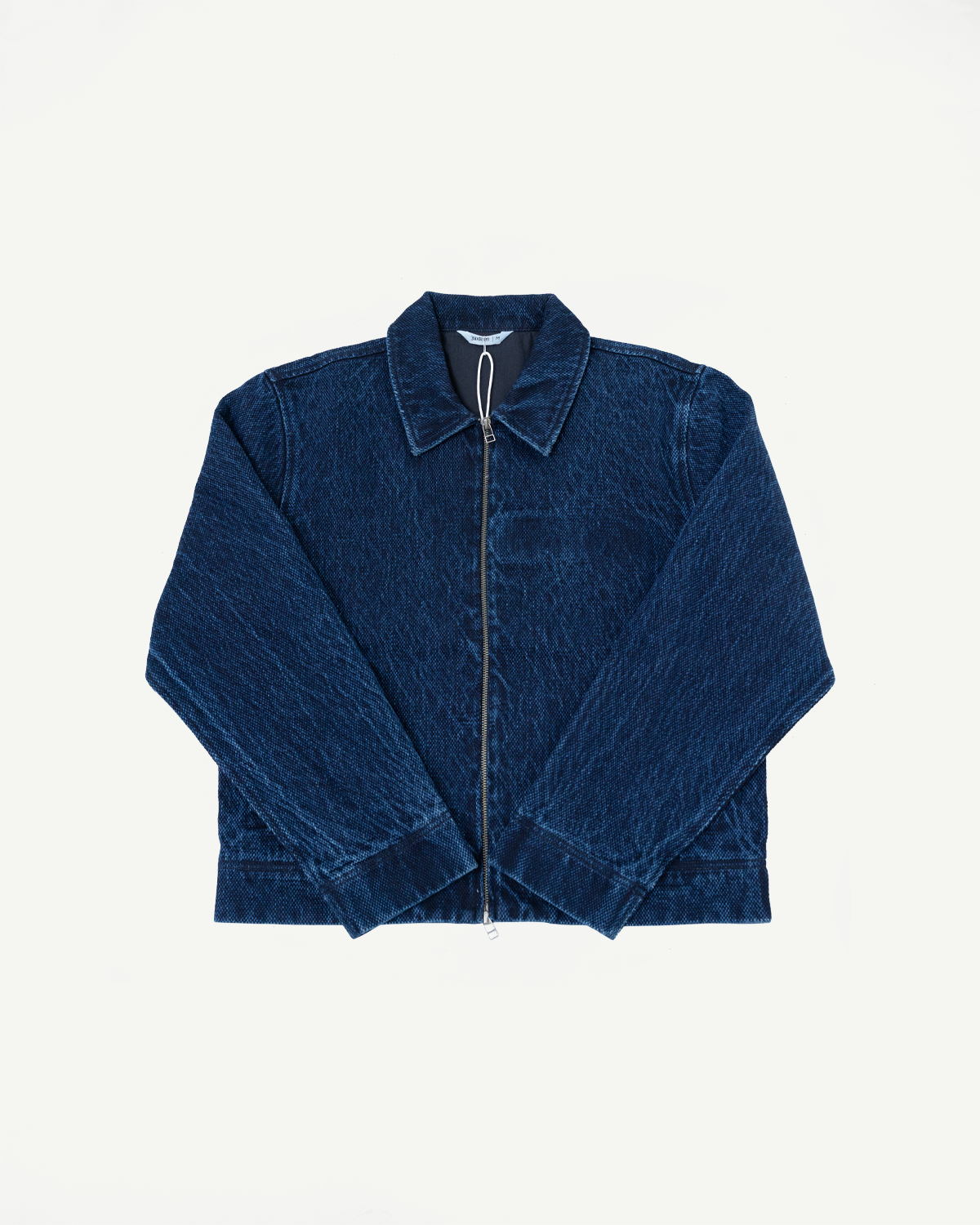 Front view flat lay of a dark blue denim jacket with a full-length silver zipper.