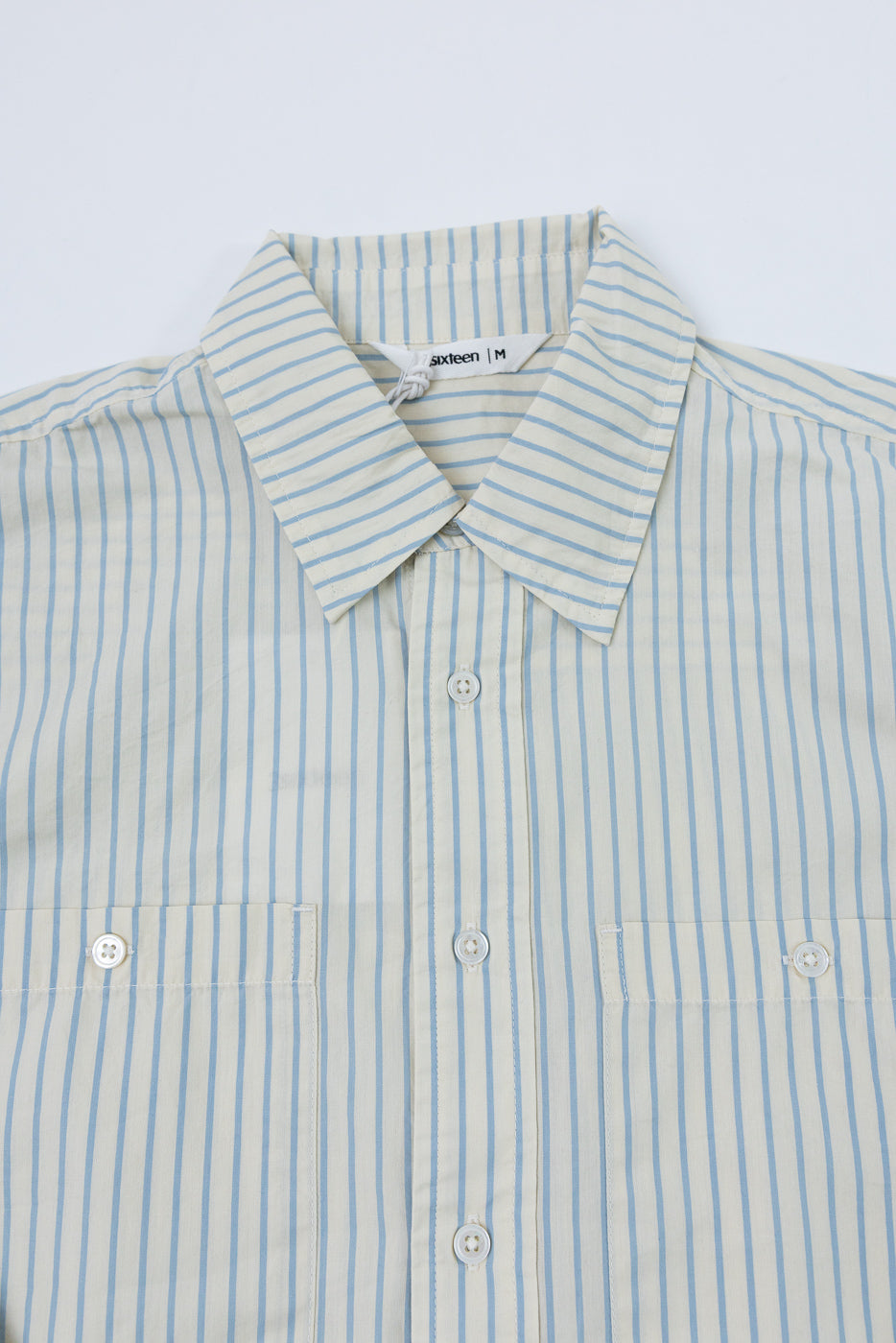 Front view close-up of a blue and white striped button-down shirt showing collar and buttons.