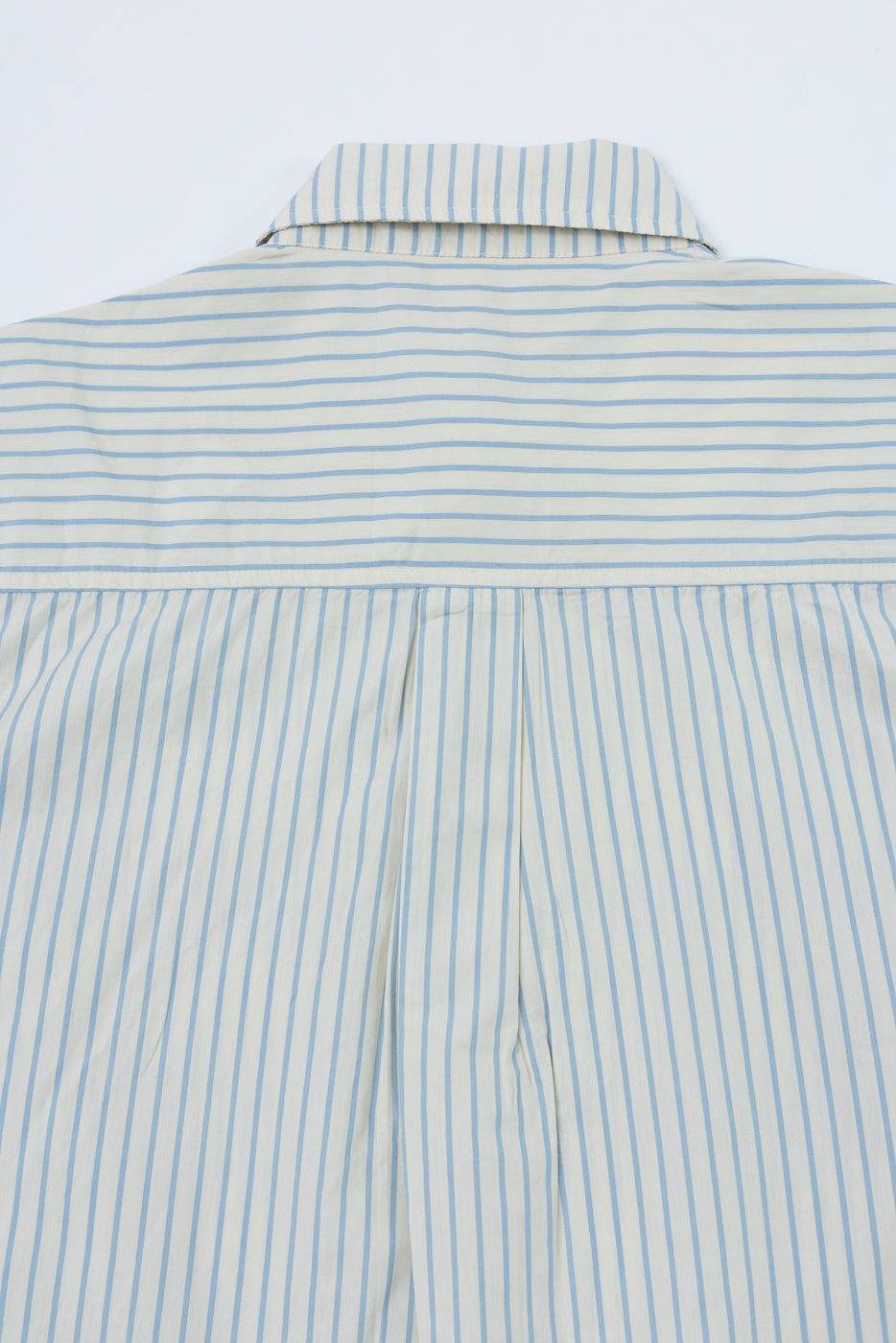 Back view close-up of a blue and white striped button-down shirt showing collar and pleat detail.