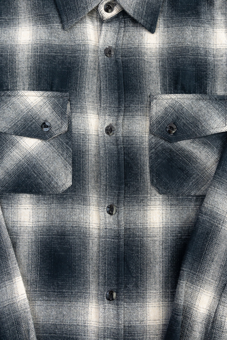 Close-up front detail of black ombre plaid flannel shirt, showing buttons, chest pockets, and collar.