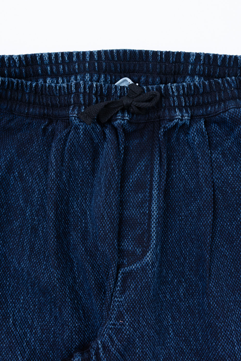 Close-up front view of navy blue textured drawstring waist on casual shorts.