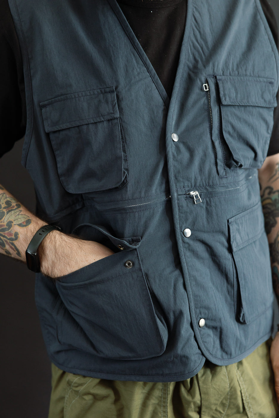 Front view close-up of a blue utility vest on a male model, 5'9