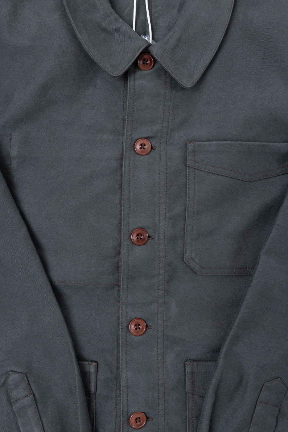 Close-up front view of a dark grey utility shirt showing button details and chest pocket.