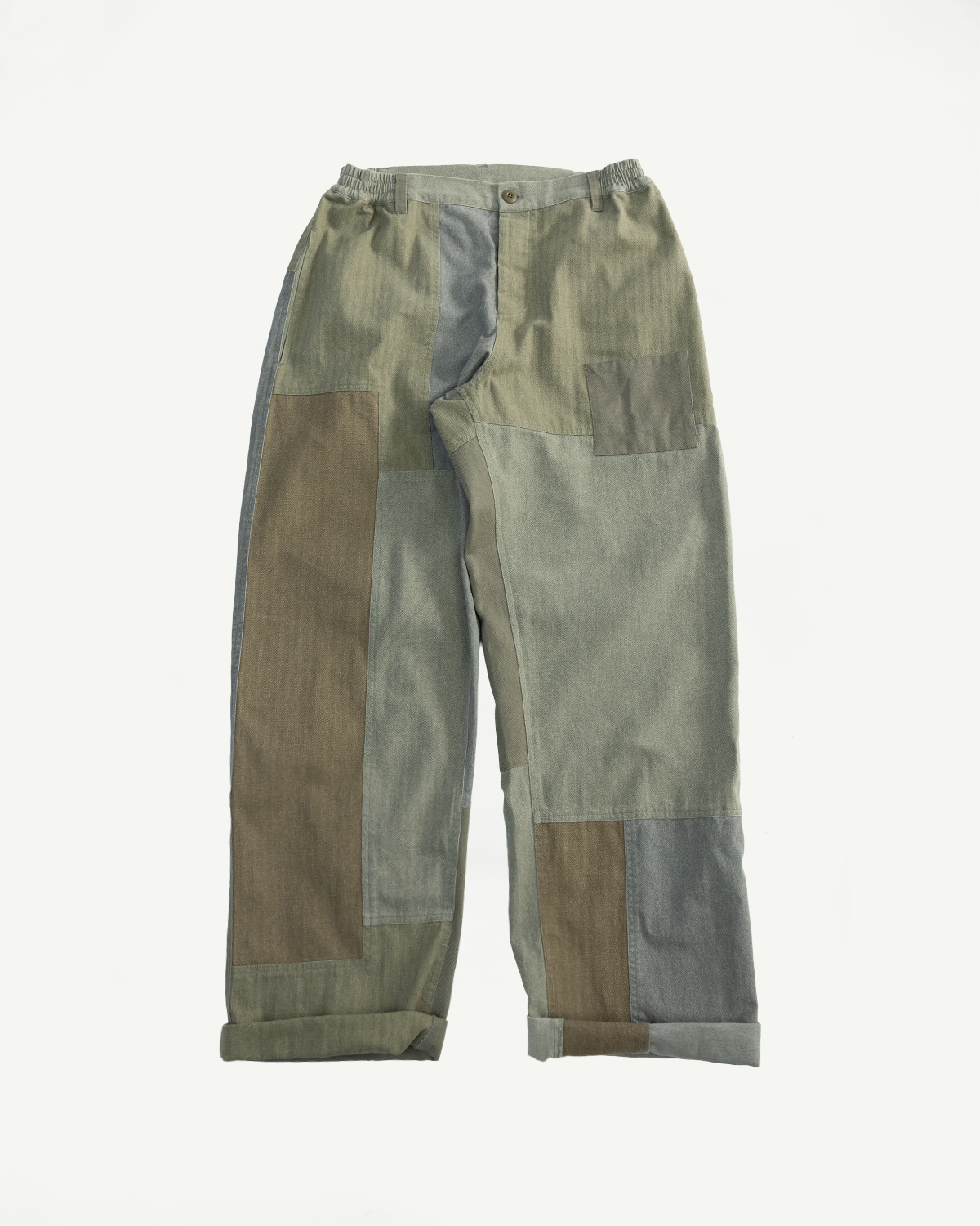 Flat lay front view of olive patchwork pants showing button waist, elastic band, and cuffed hem