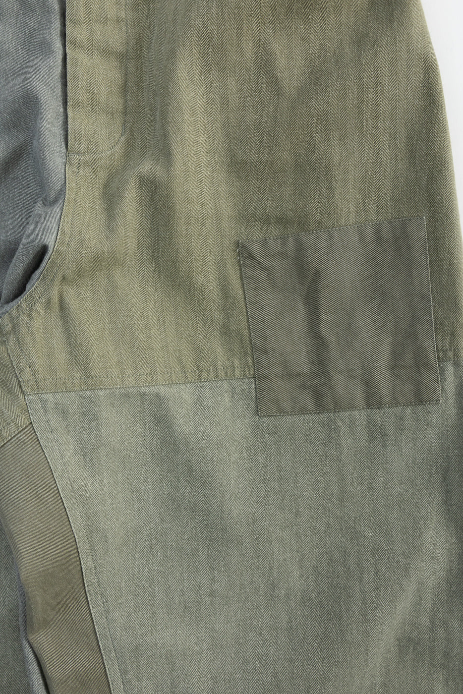 Close-up of patchwork olive harvest pant, side view, showing herringbone texture and pocket detail.