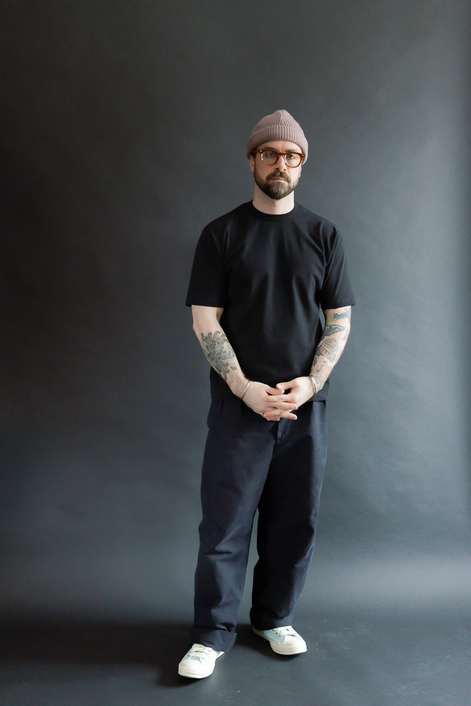 Male model 5'9, 165lbs, athletic build wearing black heavyweight boxy t-shirt, front full body view.