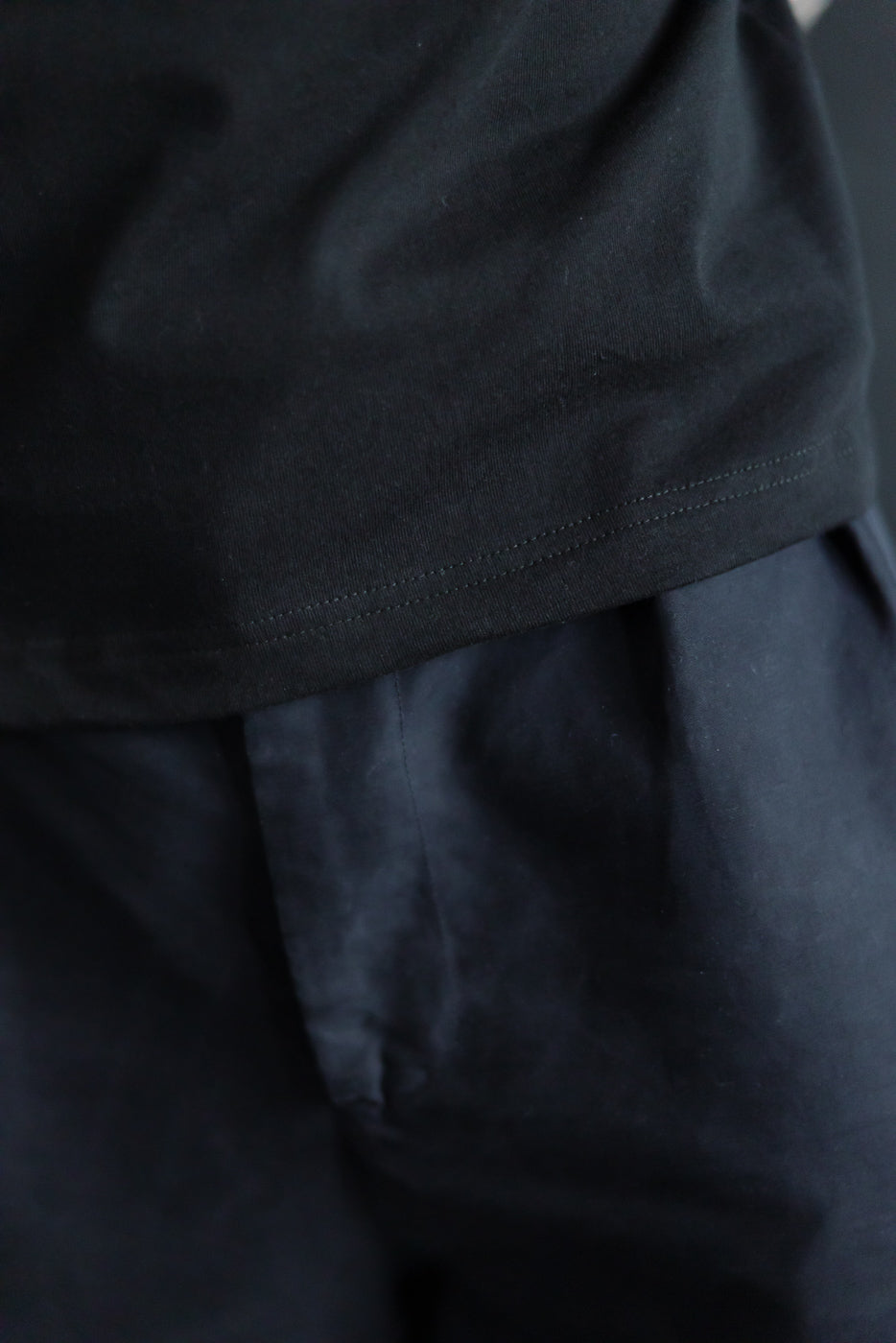 Close-up of men's black heavyweight boxy t-shirt hem, front lower section detail shown.