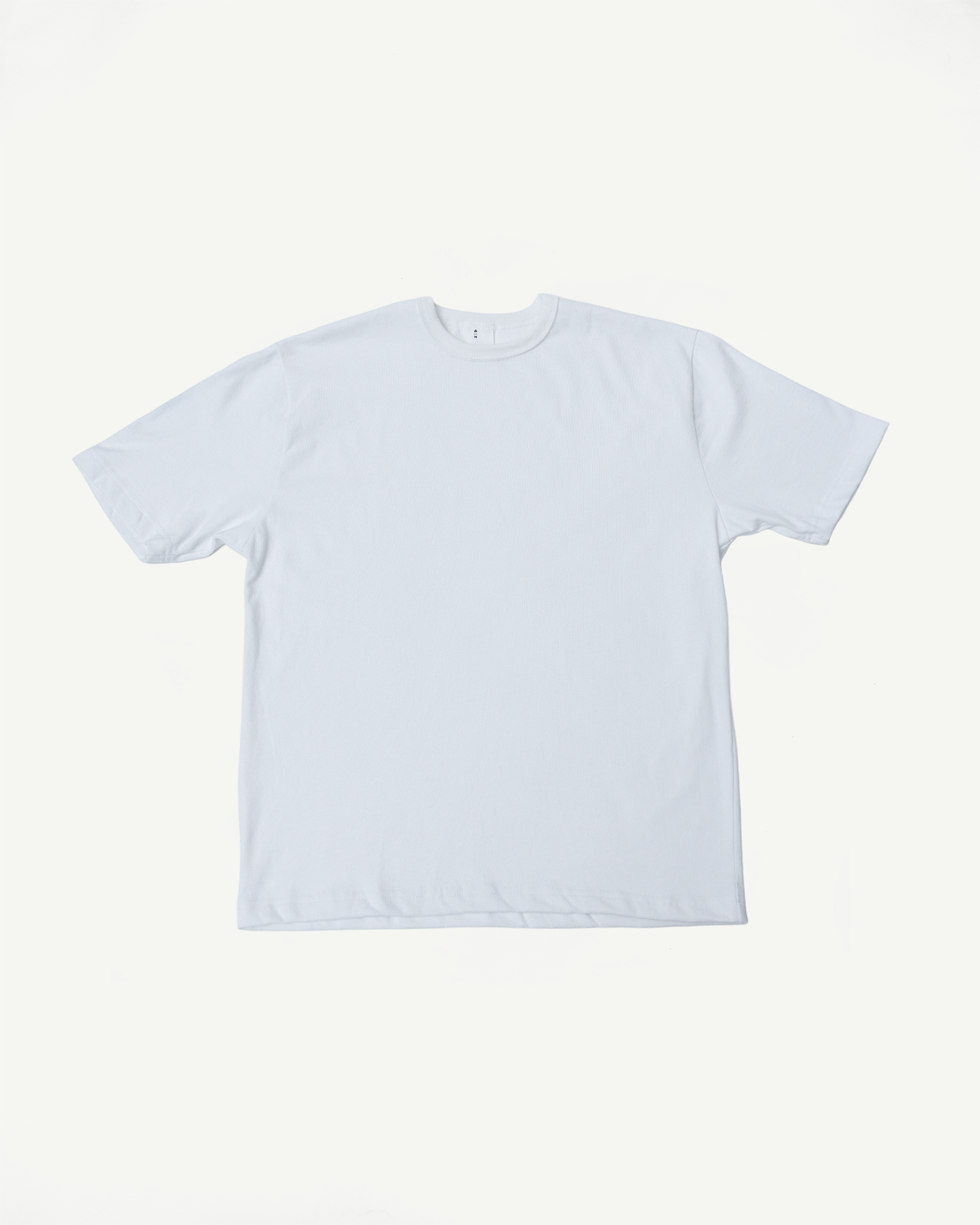 Flat lay of heavyweight boxy white t-shirt, front side, showing crew neck and short sleeves.