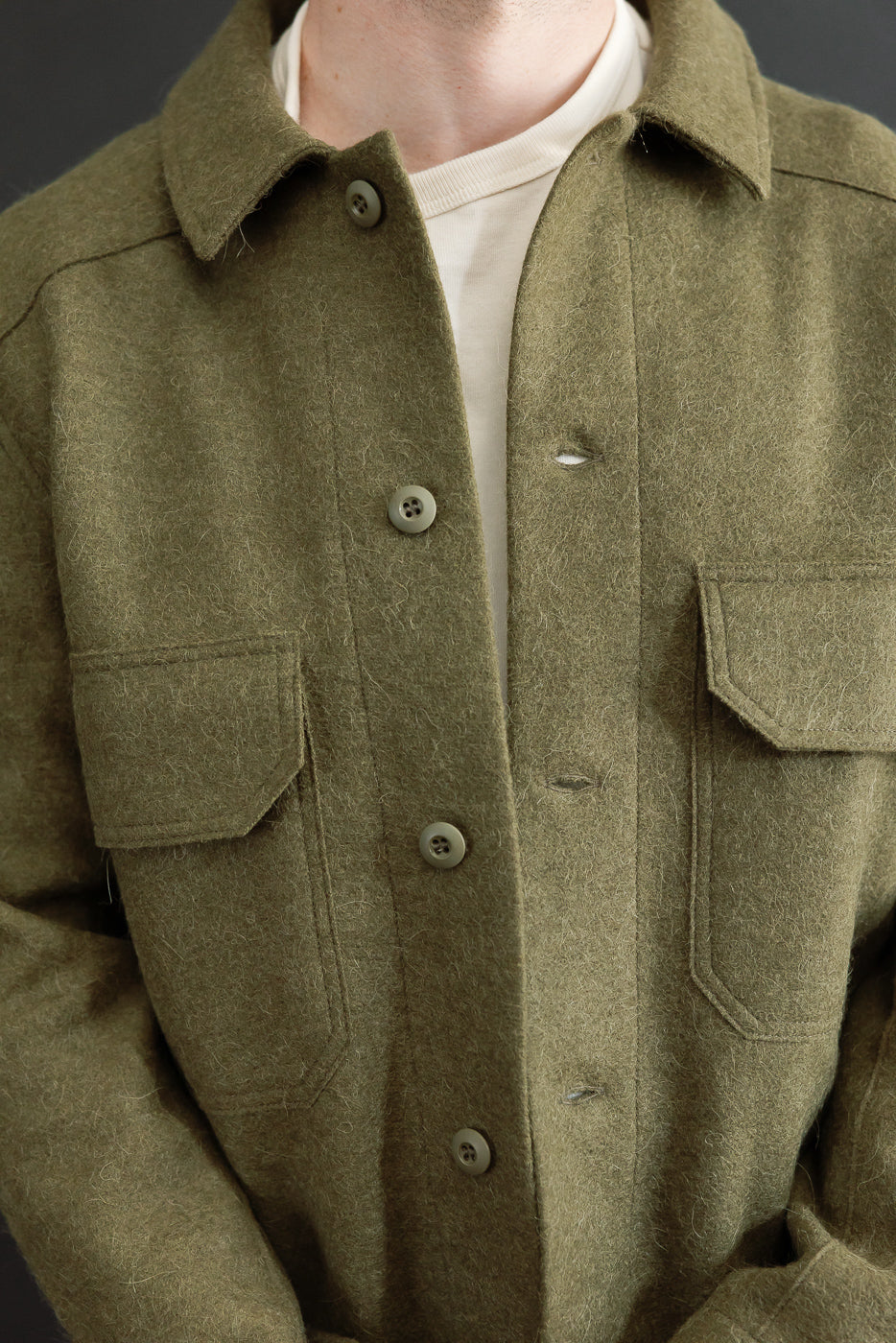 Close-up front view of olive wool shirt jacket on a male model (5'9