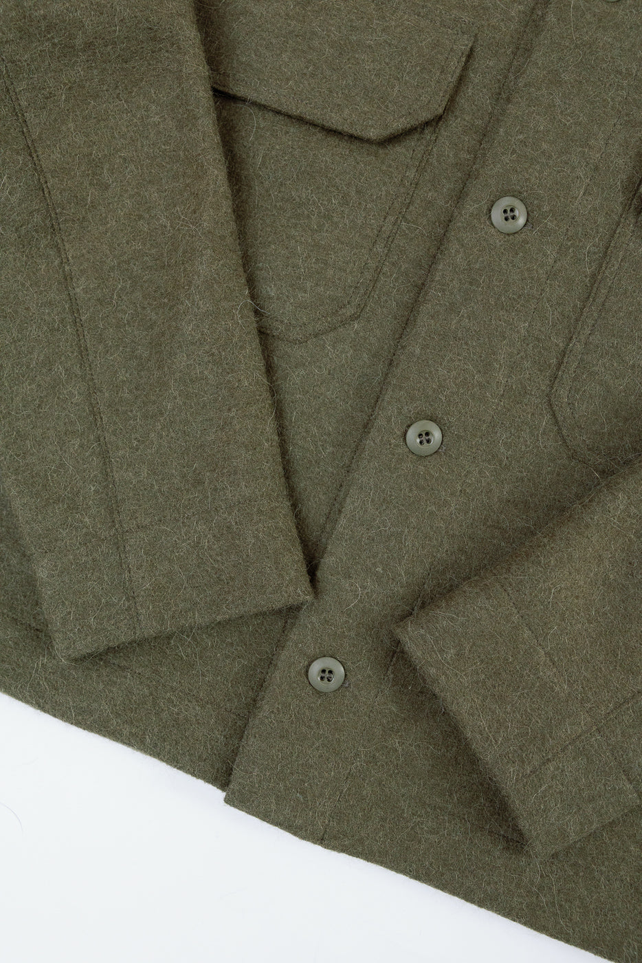 Close-up front view of an olive green wool shirt showing button details and fabric texture.