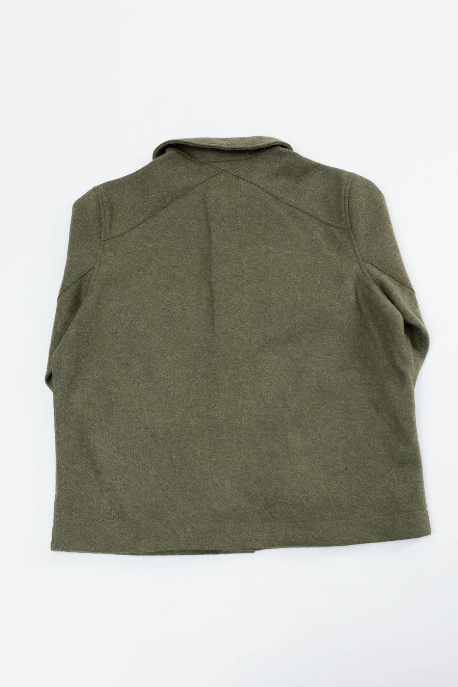Flat lay of the back of an olive green wool jacket with a pointed collar.