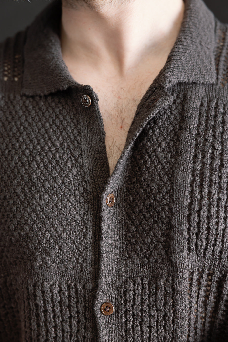Close-up of front chest and collar on men's umber knit shirt, textured fabric, brown buttons, male model 5'9