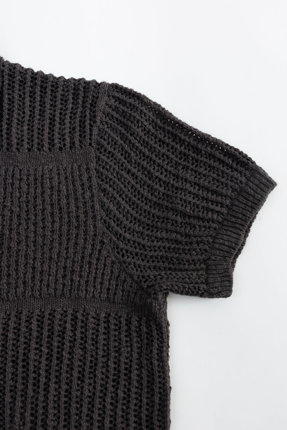 Close-up of front right sleeve and shoulder on umber short sleeve knit shirt, textured fabric