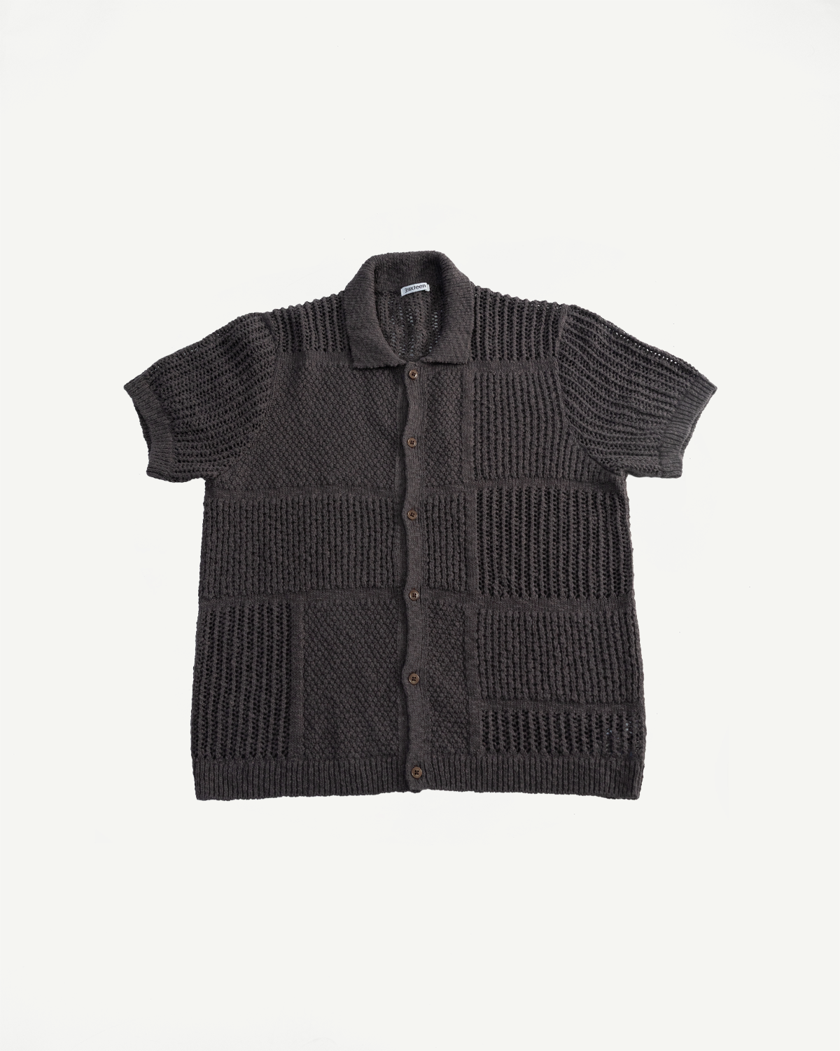 Flat lay front view of umber short sleeve knit shirt, button front, mixed textured panels, collar detail.