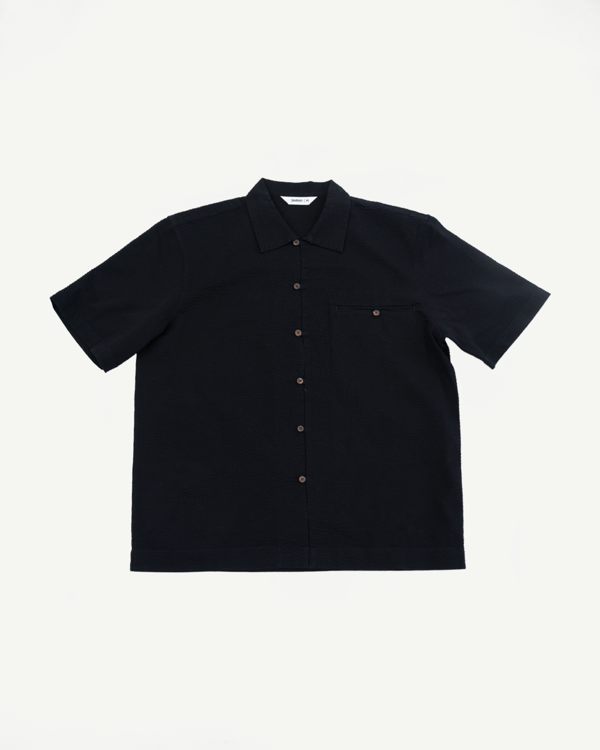 Short Sleeve Loop Shirt - Black Seersucker features a short-sleeve, button-down design with a pointed collar and single chest pocket, highlighting craftsmanship ideal for premium menswear enthusiasts at Dant.