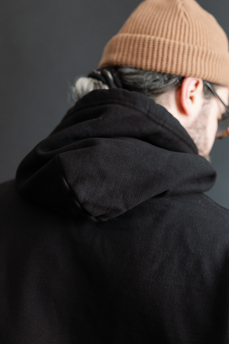 Close-up of back hood detail on 3sixteen ultra heavyweight black pullover hoodie, worn by male model, 5'9