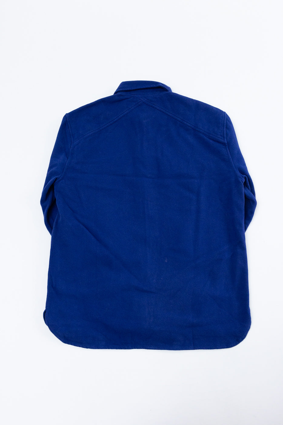 Flat lay of the back of a royal blue long-sleeve button-down shirt.