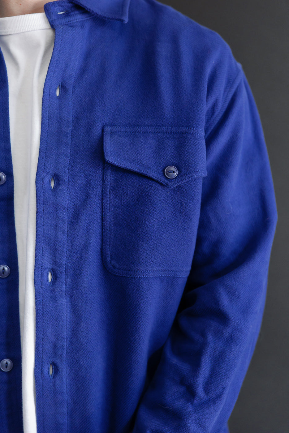 Close-up left side view of a blue textured button-down shirt on a 5'9