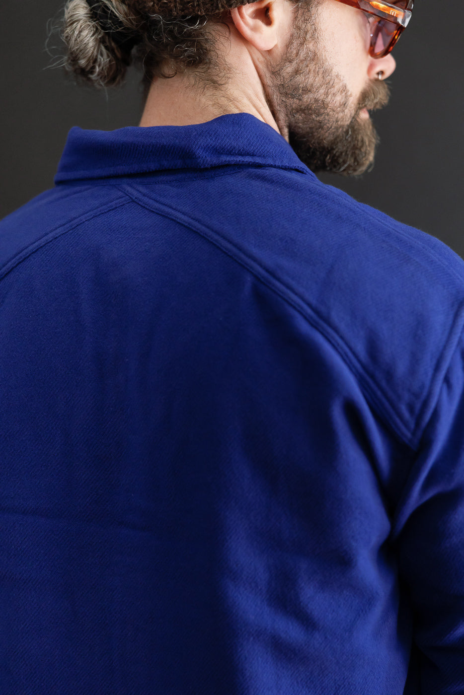 Close-up back view of a blue textured shirt on a 5'9