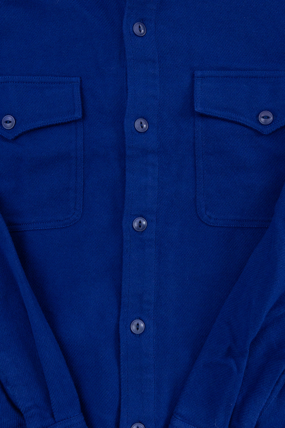Close-up front view of a blue button-down shirt showing fabric texture and chest pockets.