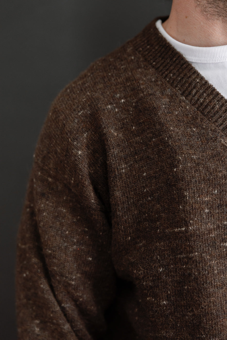 Close-up of brown knit sweater texture and ribbed collar on a male model, 5'9