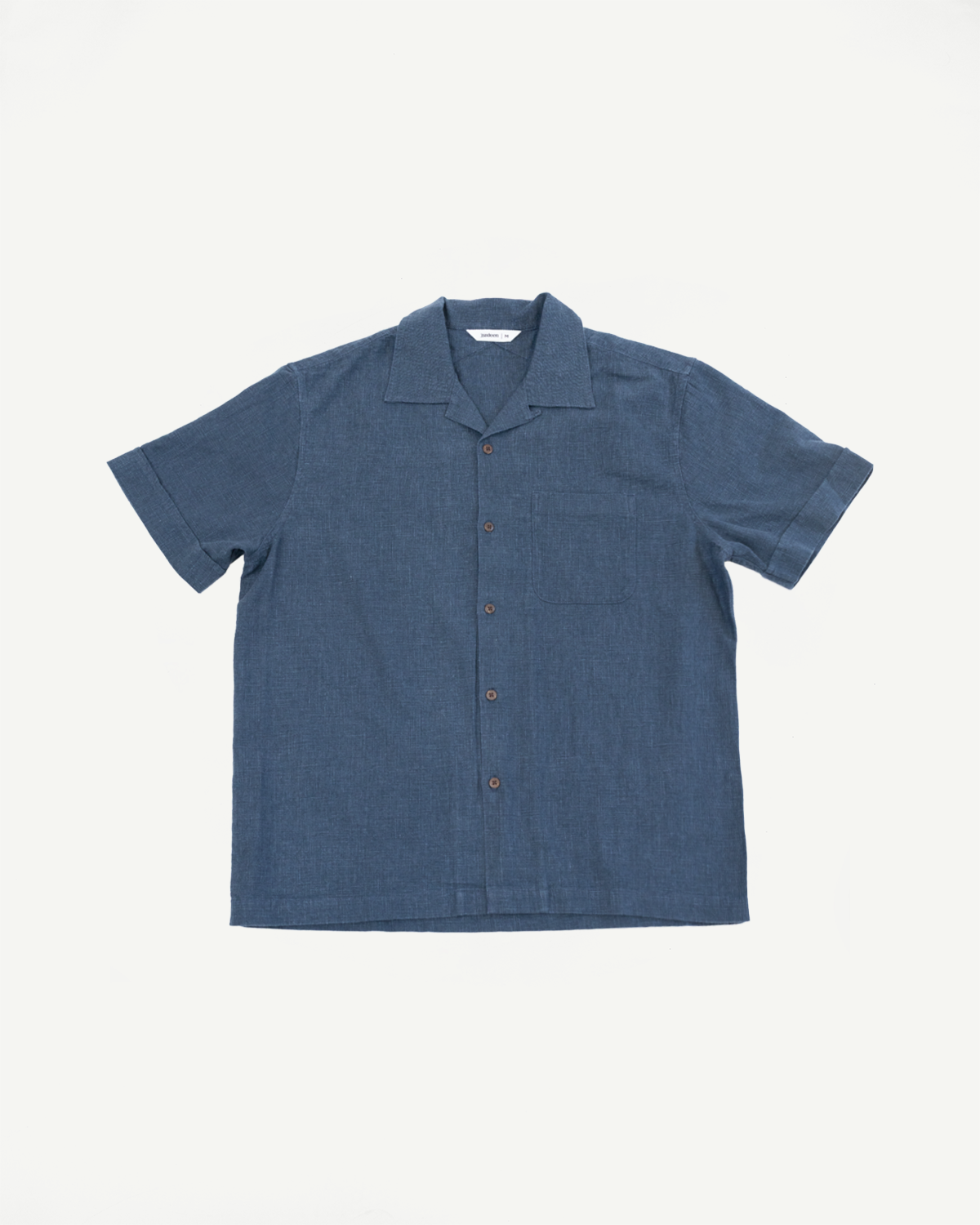 Vacation Shirt - Blue Linen is a short-sleeved, button-front shirt with a camp collar, single chest pocket, and coconut buttons, crafted from enzyme-washed linen for a relaxed, vintage-inspired look.
