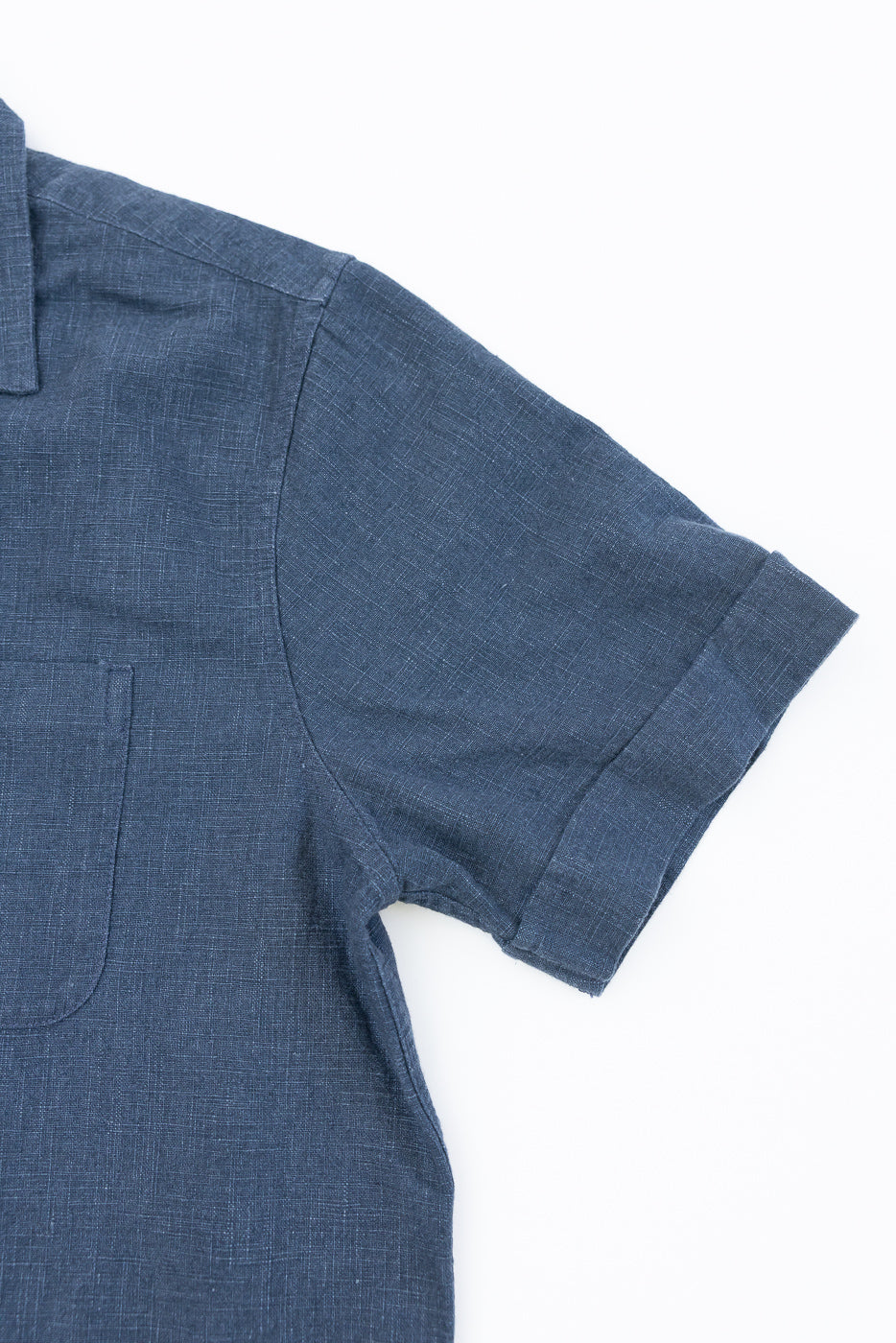 Vacation Shirt - Blue Linen featuring a mid-blue linen fabric with a textured finish, classic camp-style collar, and a single chest pocket, laid flat emphasizing its refined, relaxed design.