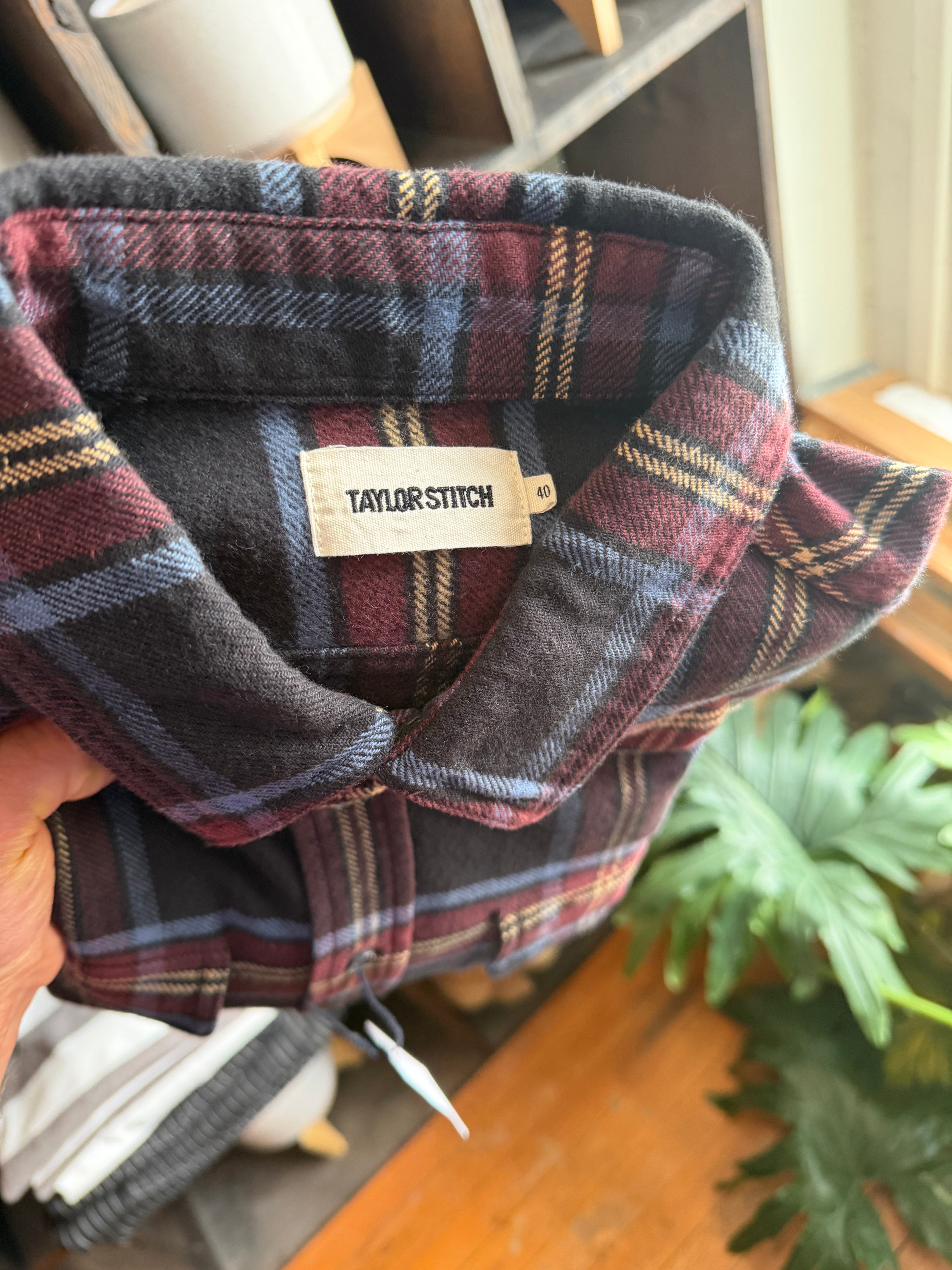 Close-up of Taylor Stitch men's plaid flannel shirt collar and neck tag, front detail