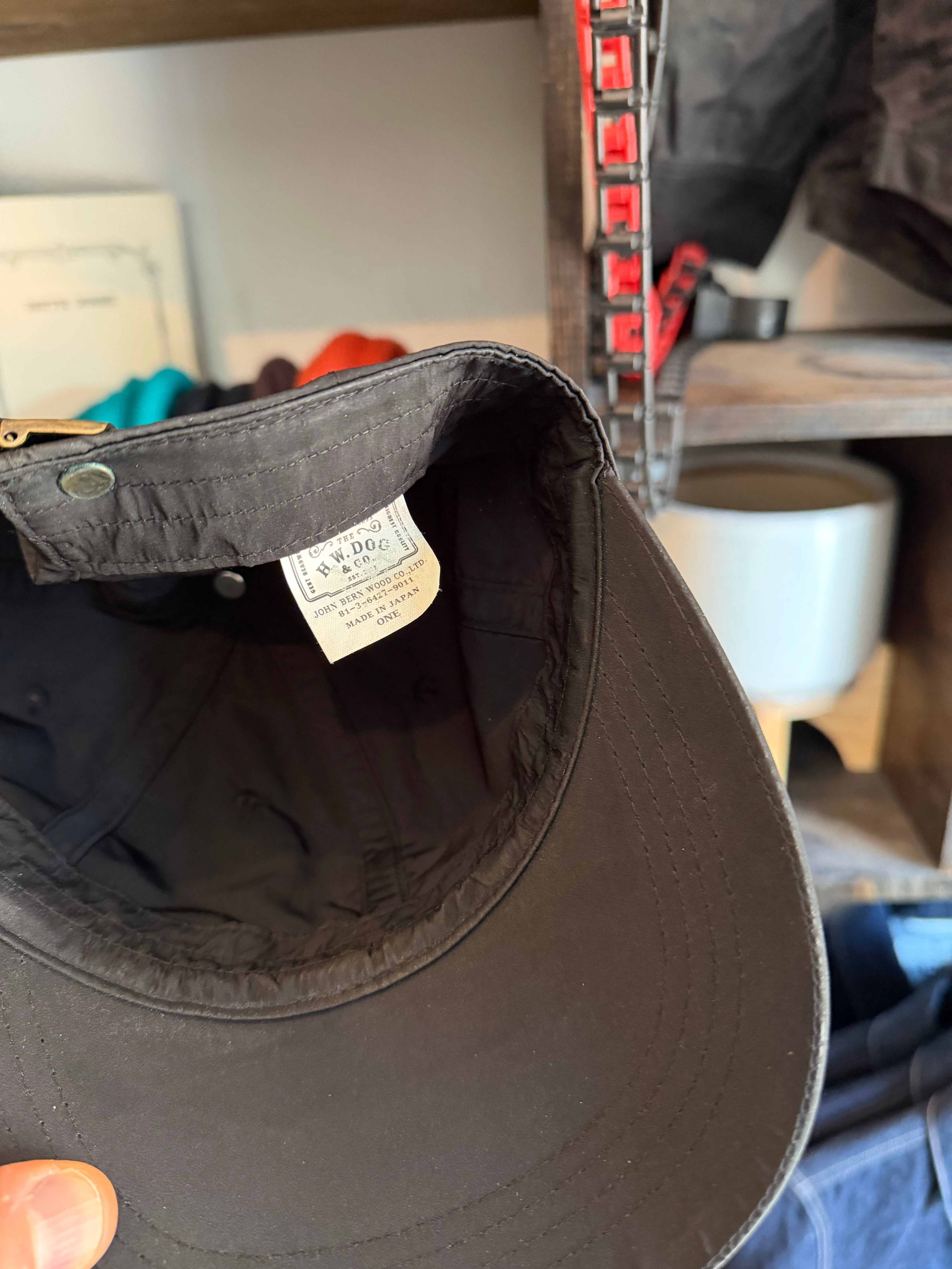 Close-up of black cap's interior showing tag, stitching, and fabric texture